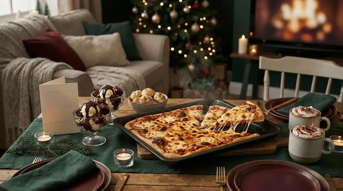 Christmas pizza night table with brownie sundaes, hot chocolate and a lit tree behind